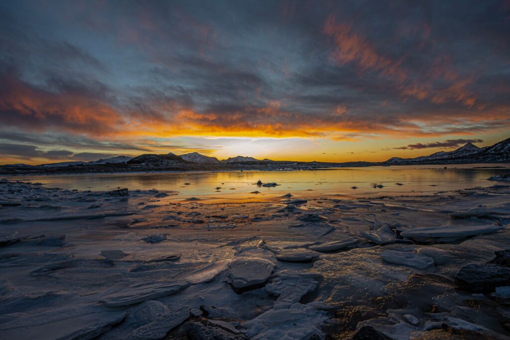 Sunset over broken sea ice along an Arctic shoreline