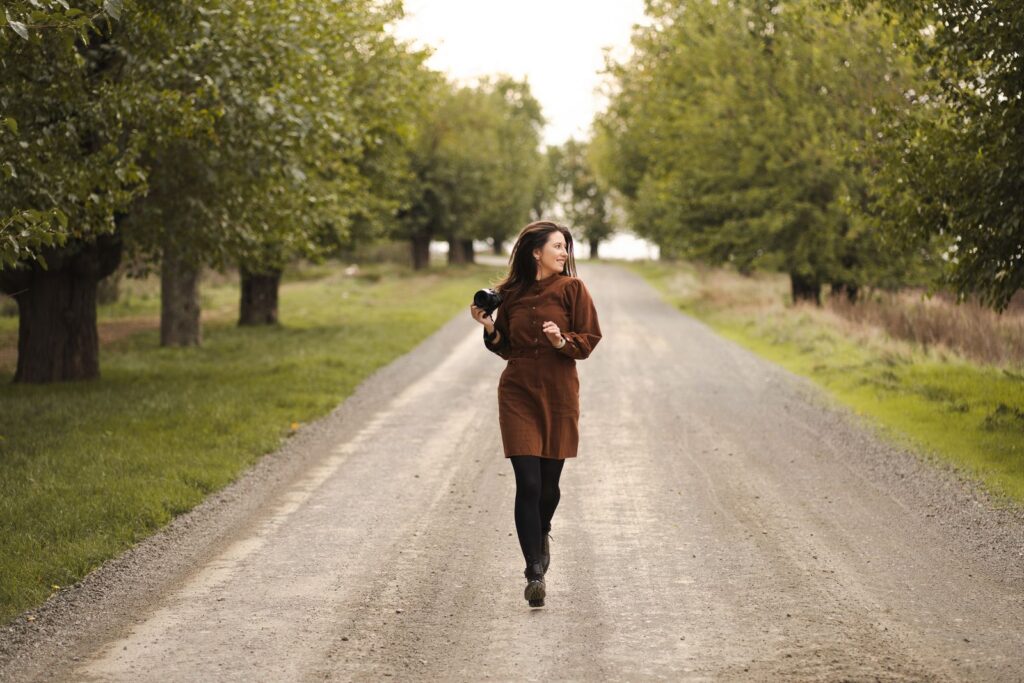 Woman walking confidently down a tree lined country road